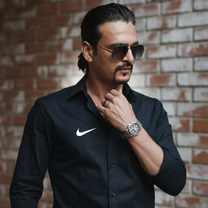 Ahmed Afridi wearing a black shirt against a brick wall